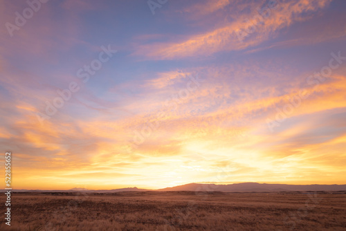 Colorful sunrise over distant mountains and dry plains