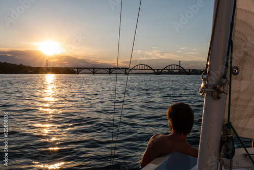 Man looking at the sunset from the yacht
