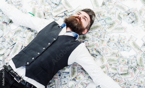 Businessman lying in many banknotes. Saving money. Business success. Rich millionaire, billionaire. photo