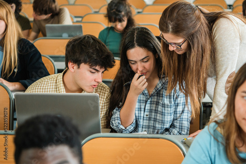 Teacher helping students with assignment