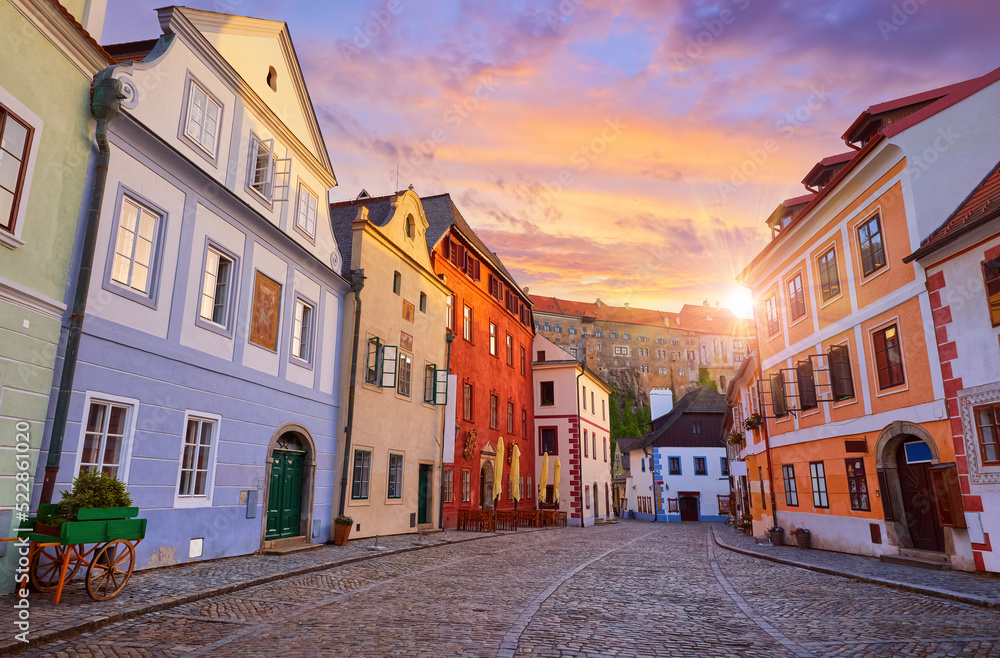 Cesky Krumlov, Czech Republic. Ancient street with old houses and paving stones road. Evening sunset with sunlight.