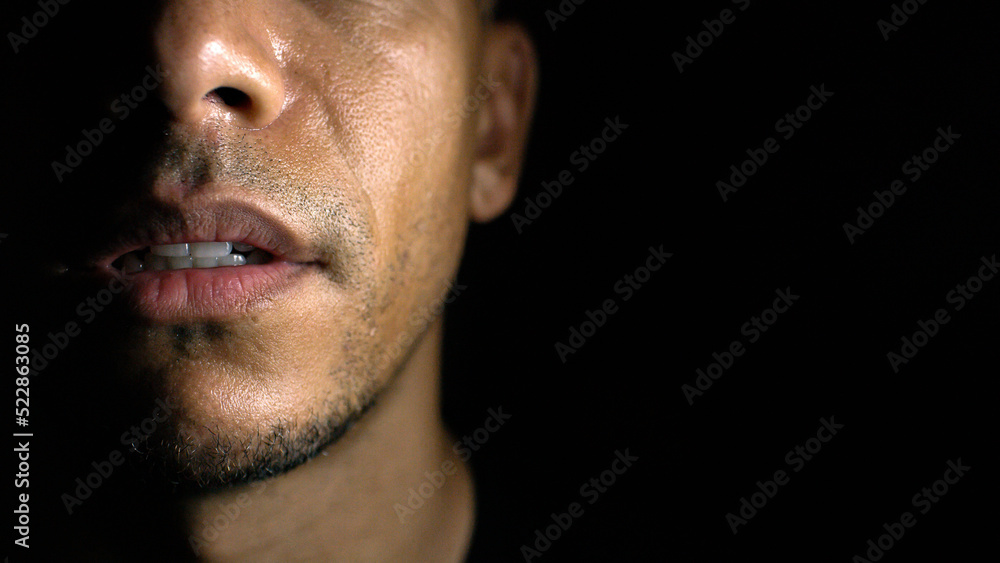 Half face portrait of man in the shadows with space for text. Half face portrait of man in the shadows with space for text.