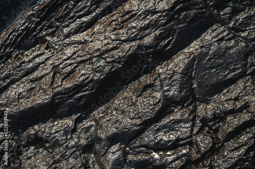 Textured background of wet rocky formation