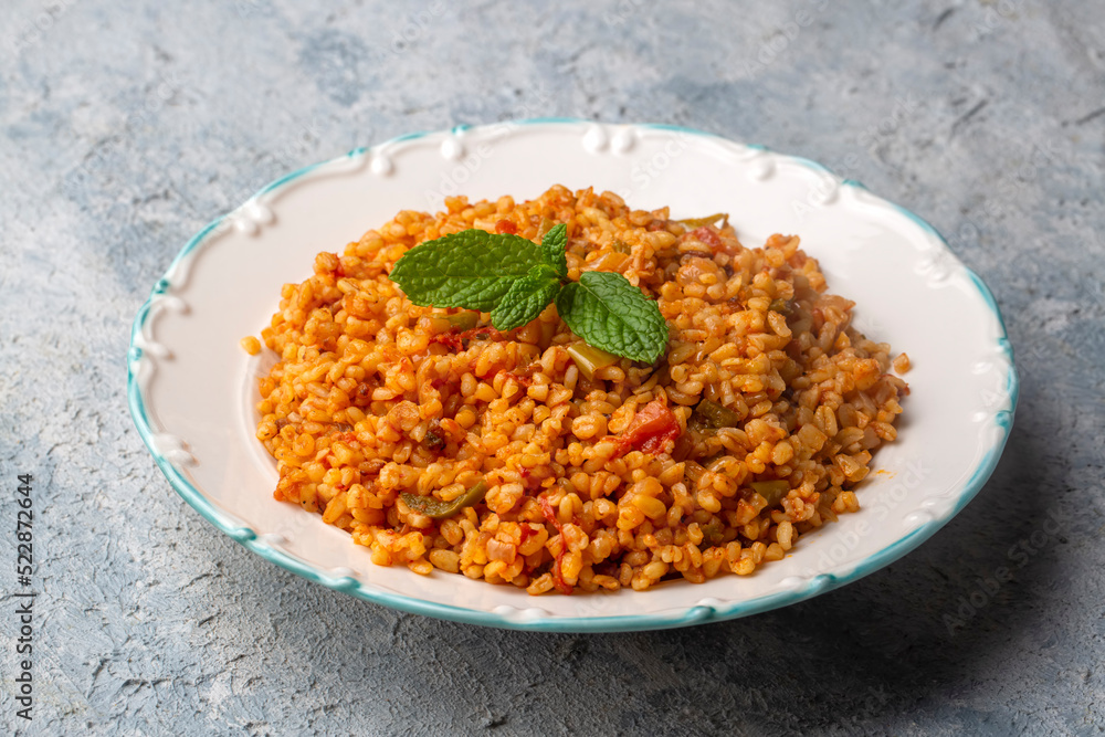Traditional turkish bulgur pilaf with tomato sause in plate (Turkish name; meyhane pilavi) Traditional turkish bulgur pilaf with tomato sause in plate (Turkish name; meyhane pilavi)