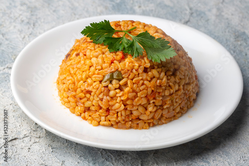 Traditional turkish bulgur pilaf with tomato sause in plate (Turkish name; meyhane pilavi)