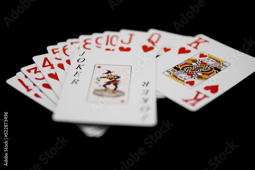 A set of play cards with a joker on top