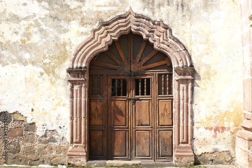 Puerta de madera antigua en arco decorado