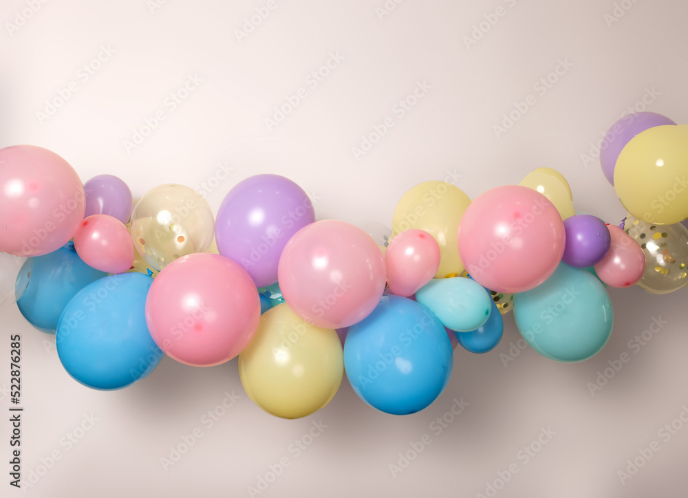 A close up image of a soft pastel balloon garland against a pink background A close up image of a soft pastel balloon garland against a pink background