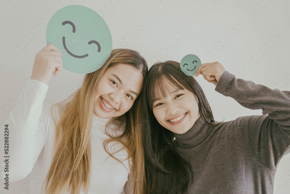 Φωτογραφία Happy young Asian women holding smile emoji face, positive mental health concept