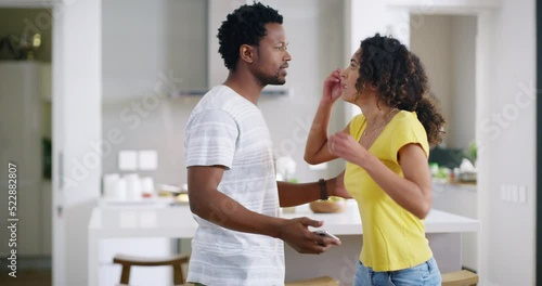 Arguing, cheating and marriage problems while yelling and talking about issues in their relationship. Husband and wife having a fight about messages on a phone. Unhappy couple fighting about divorce photo