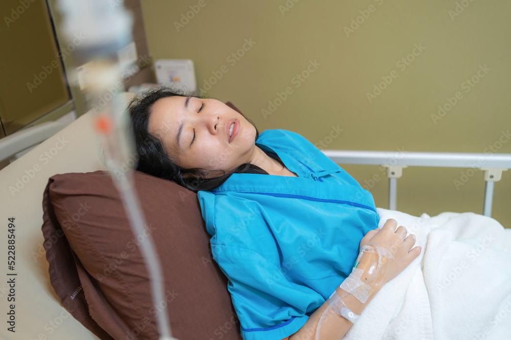Patient Asia woman on the bed with saline solution and monitor blood pressure at hospital ward room. Treatment emergency recovery after surgery. Hypertension and hypotension. Healthcare and medical Patient Asia woman on the bed with saline solution and monitor blood pressure at hospital ward room. Treatment emergency recovery after surgery. Hypertension and hypotension. Healthcare and medical