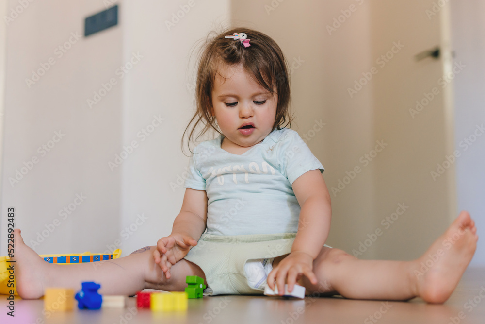 Baby girl building towers from small wooden blocks. Baby development. Baby girl building towers from small wooden blocks. Baby development.