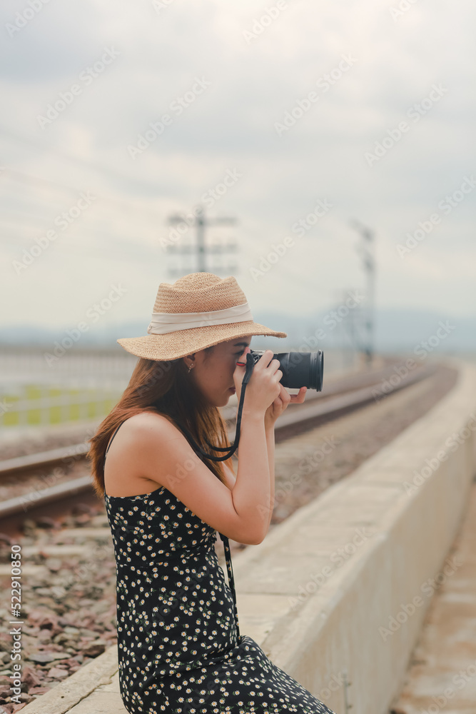 portrait of woman taking photo with digital camera,tourist on railway with hipster style