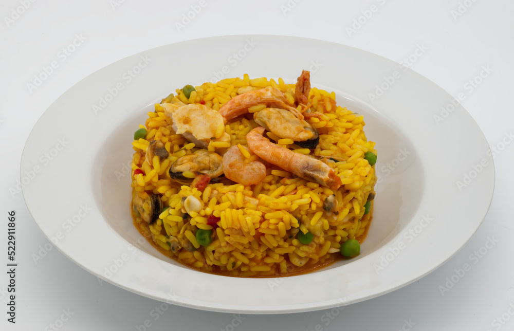 Traditional Spanish Paella in a white disch isolated on white background. Traditional Spanish Paella in a white disch isolated on white background.
