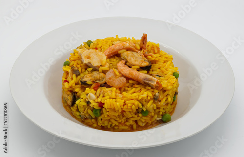 Traditional Spanish Paella in a white disch isolated on white background.