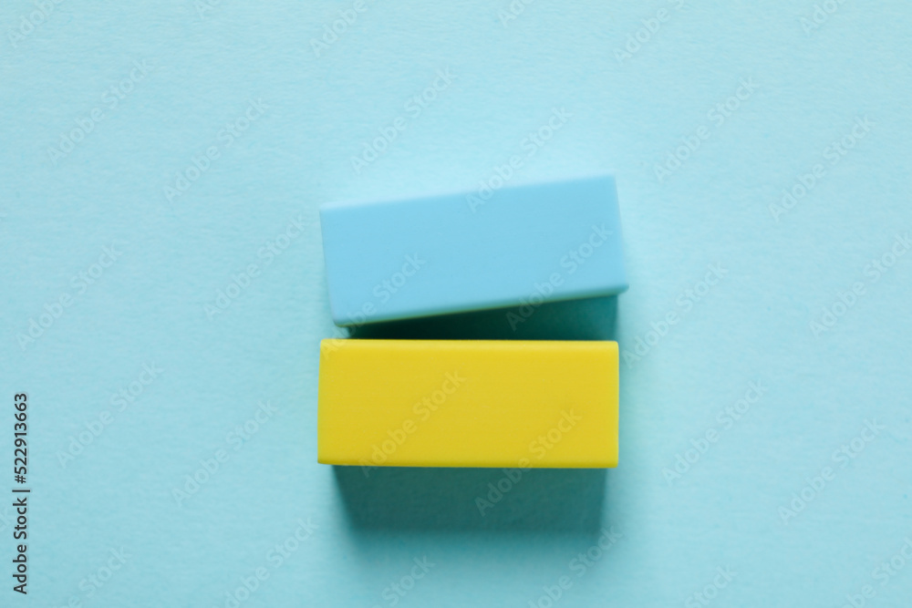 Blue and yellow erasers on blue background Blue and yellow erasers on blue background