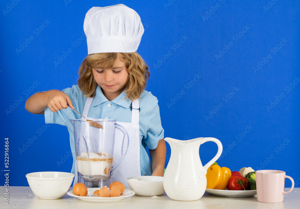 Child chef dressed cook baker apron and chef hat isolated on studio background. Healthy nutrition kids food. Child chef dressed cook baker apron and chef hat isolated on studio background. Healthy nutrition kids food.