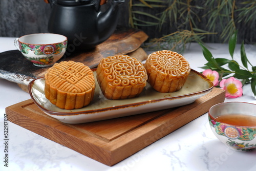 Mooncake, Moon cake-Round shaped Chinese traditional pastry with tea cups on white background, Mid-Autumn Festival concept, close up.