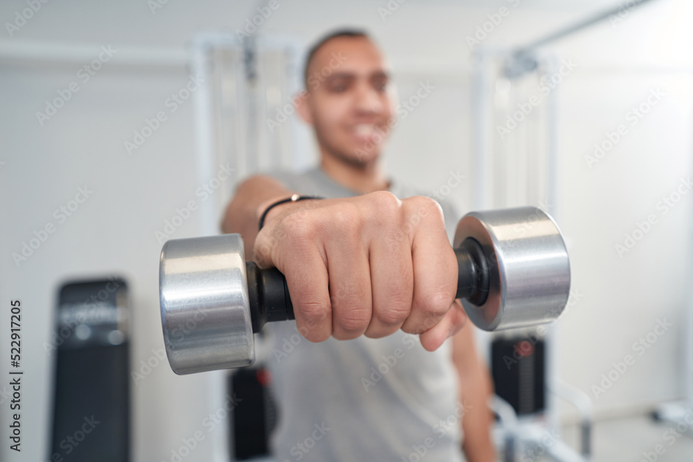 Man doing exercise with dumbbells in physical therapy clinic Man doing exercise with dumbbells in physical therapy clinic