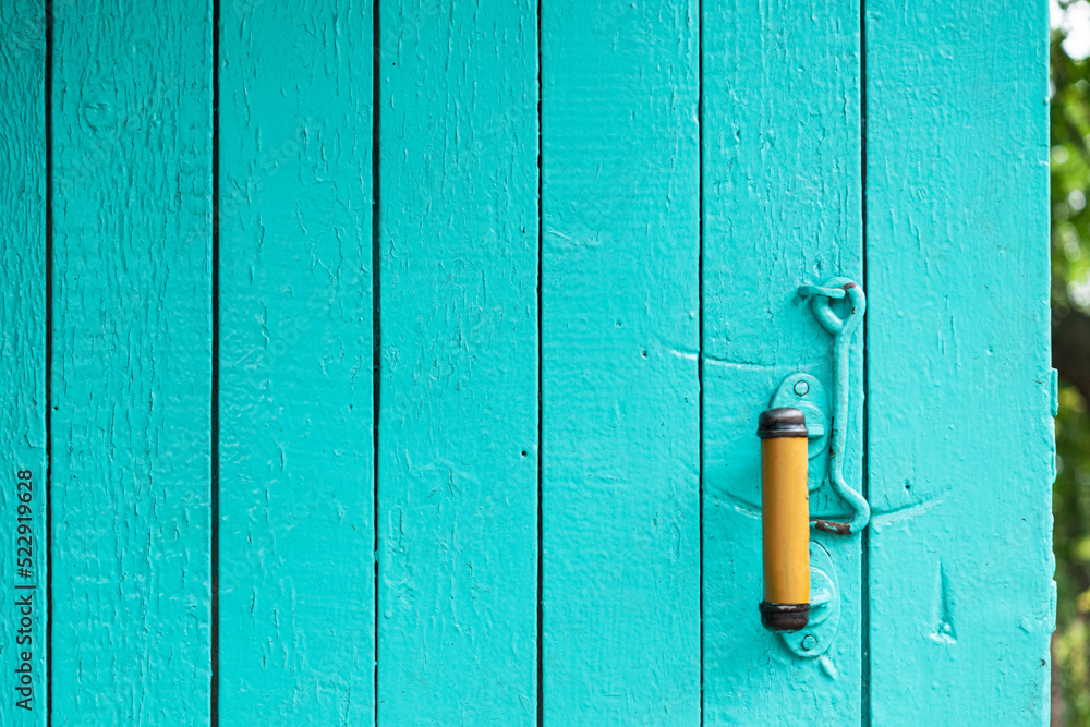 Entrance door in the village. Old texture, aqua color. Entrance door in the village. Old texture, aqua color.