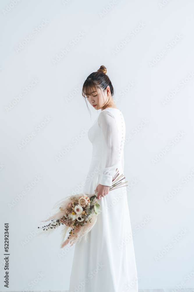 Obraz premium ウェディングドレスを着てブーケを持った花嫁