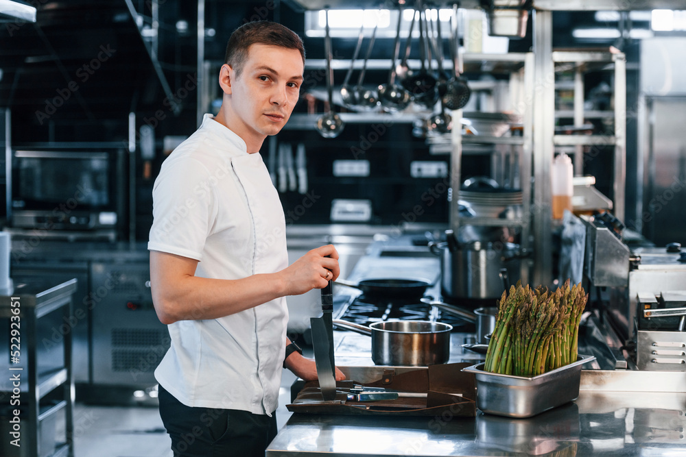 With knife. Chef is on the kitchen preparing food With knife. Chef is on the kitchen preparing food