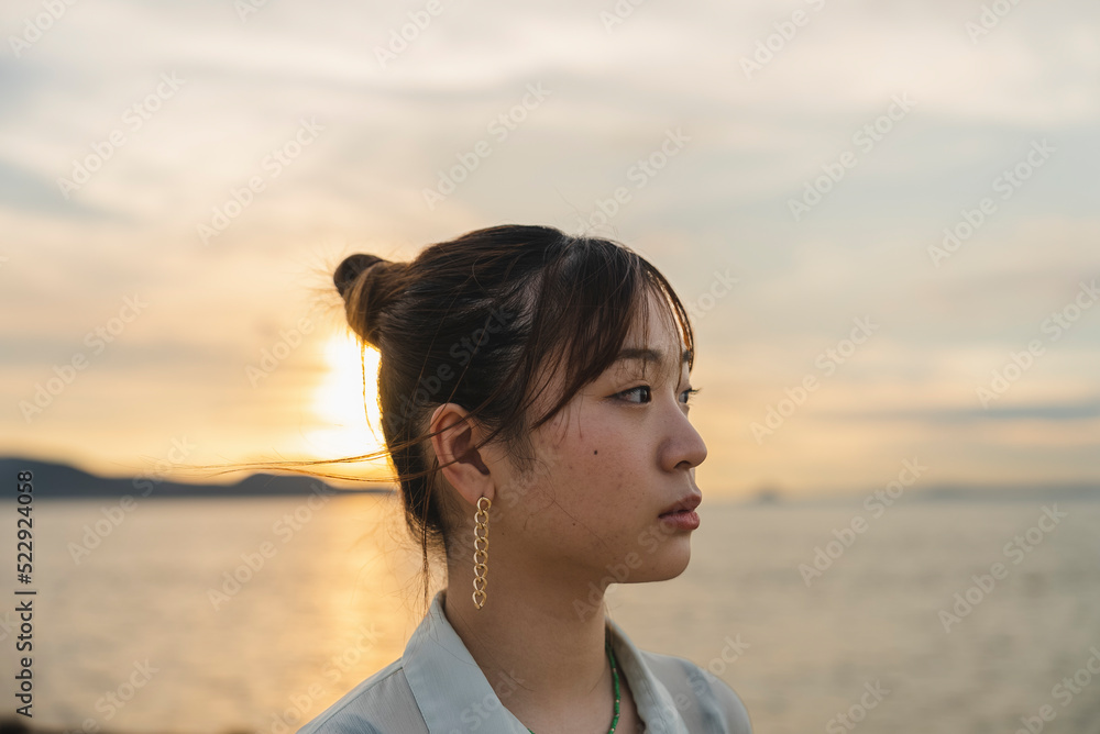 夕暮れの海を散策する女性 夕暮れの海を散策する女性