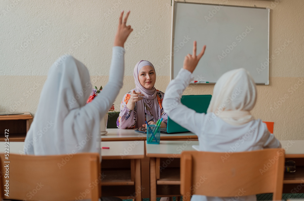 Muslim school kids raise their hands to answer Arab teacher questions