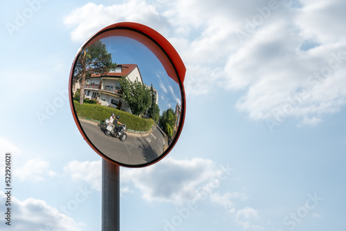 A motorcyclist passes in the mirror