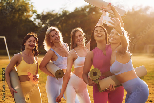 Smiling and standing. Group of women have fitness outdoors on the field together