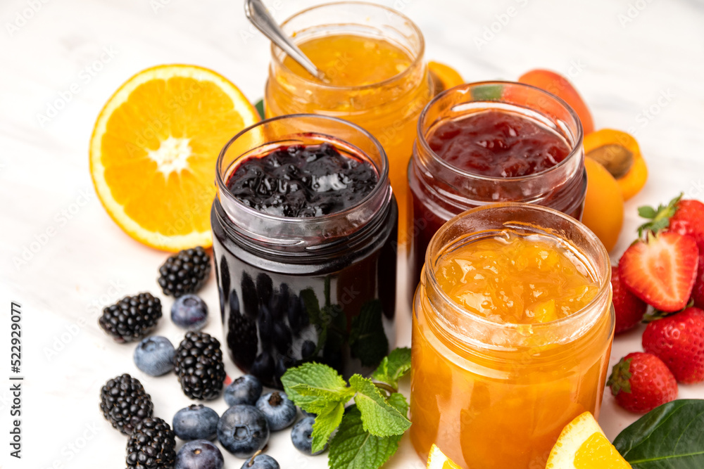 Many different jars of jam strawberry jam, apricot jam, orange jam, blueberries and blackberries Many different jars of jam strawberry jam, apricot jam, orange jam, blueberries and blackberries