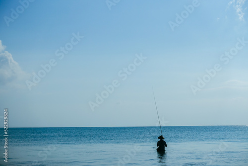Fisherman wading in the ocean in Bali, Indonesia