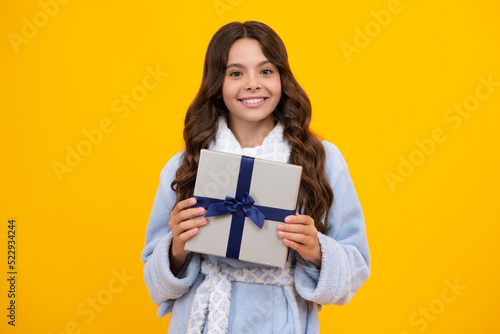 Portrait of teenager child girl 12, 13, 14, years old holding Christmas gift box. Teen giving birthday gift.