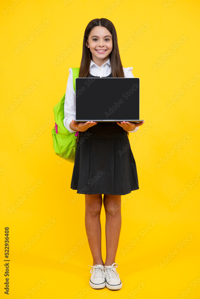 Teen schoolgirl hold laptop on isolated studio background. Cchool student learning online, webinar, video lesson, distance education. Screen of laptop computer with copy space mockup. Teen schoolgirl hold laptop on isolated studio background. Cchool student learning online, webinar, video lesson, distance education. Screen of laptop computer with copy space mockup.