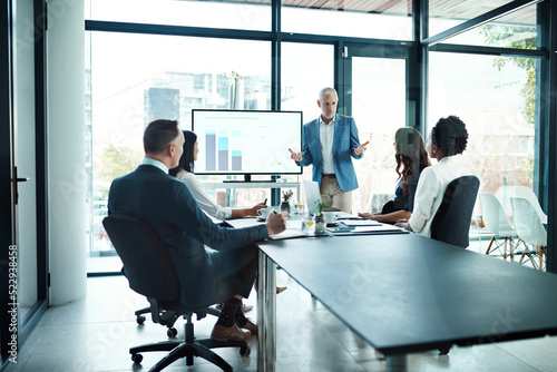 Manager, leader and boss talking to his team or group of colleagues in a presentation, seminar or workshop in a boardroom meeting. Discussing strategy, the company mission and vision for the future © K Seisa/peopleimages.com