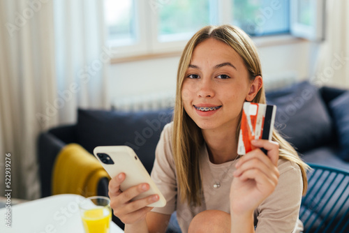 teenager using smartphone for online shopping from her home