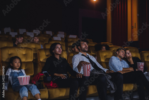 Young and adult audiences are watching movies in cinema.