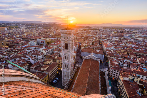 The bell tower Giotto's Campanile with the rooftop of Santa Maria del Fiore Duomo in Florence during beautiful sunset.