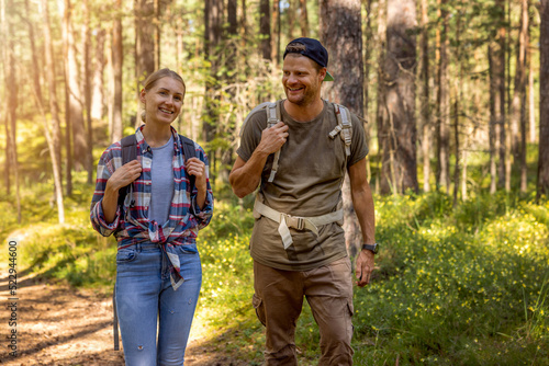 young couple ⁬with backpacks on a hike in forest. backpacking trip, summer adventure vacation