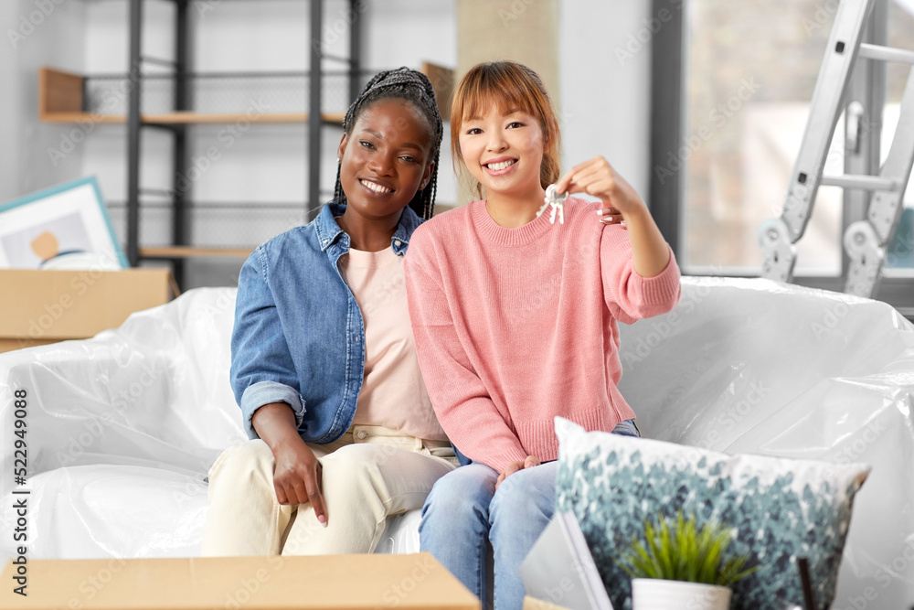 moving, people and real estate concept - happy smiling women with keys at new home moving, people and real estate concept - happy smiling women with keys at new home