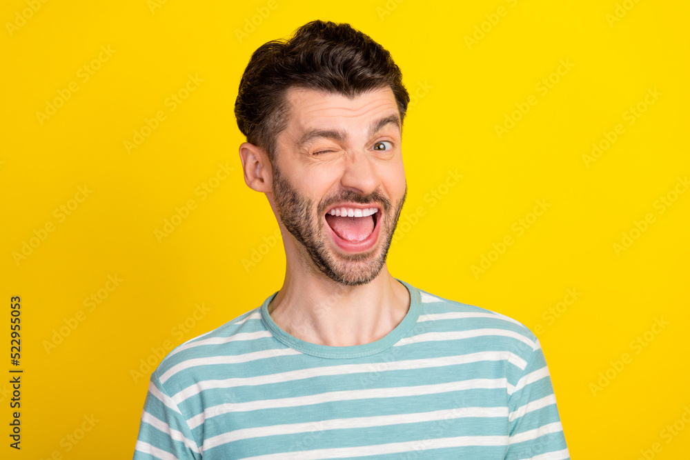 Photo of hooray guy blink wear striped t-shirt isolated on yellow color background Photo of hooray guy blink wear striped t-shirt isolated on yellow color background