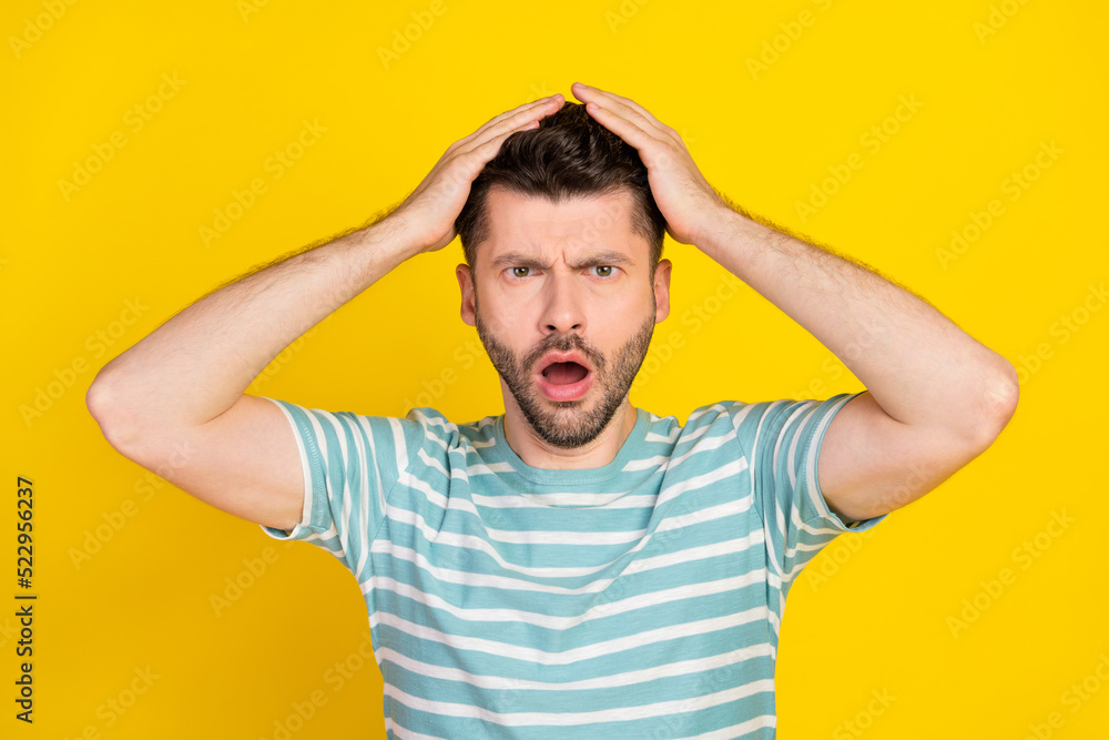 Closeup photo of young attractive funny guy reaction hands head shock how that happened isolated on yellow color background Closeup photo of young attractive funny guy reaction hands head shock how that happened isolated on yellow color background