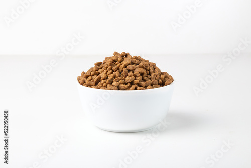 Food for cats and dogs in a white bowl on a white background.	