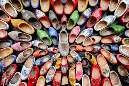 Zapatos de madera adornados con diferentes motivos regionales colgados en una pared.. Zuecos de madera, calzado típico tradicional de Países Bajos- photo