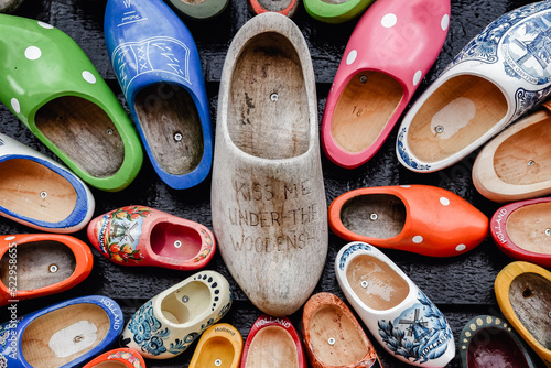 Zapatos de madera adornados con diferentes motivos regionales. Zuecos de madera, calzado típico tradicional de Países Bajos. El zapato grande tiene un mensaje "Kiss me under the woodenshoe"