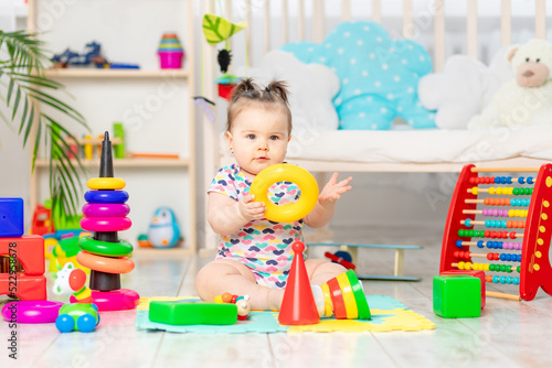 the baby is playing at home in the nursery. Toys for small children. A child with educational toys. Early development © Any Grant