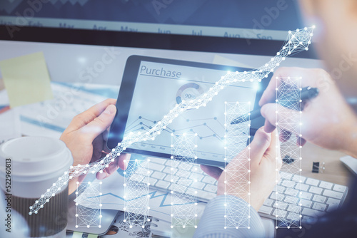 Double exposure of man's hands holding and using a phone and financial chart drawing. Market analysis concept.