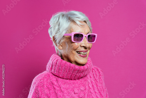 image of a beautiful and elegant old influencer woman. Cool grandmother posing in studio wearing fashionable clothes photo