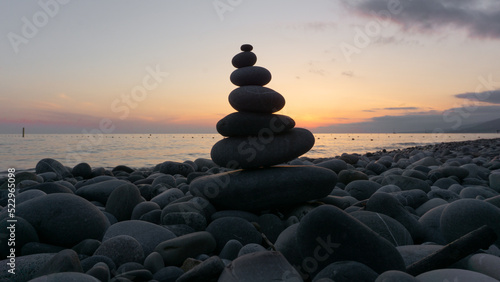 Stack of zen stones on the beach at sunset, beautiful seascape. Made of stone tower as rest balance vacation concept.
