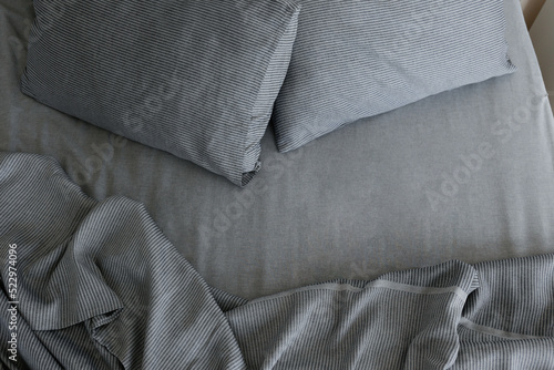 Foto Empty bed with headboard, perfectly clean and ironed sheets, puffy pillows in natural sun light